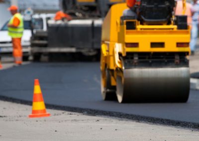 man sitting on asphalt roller